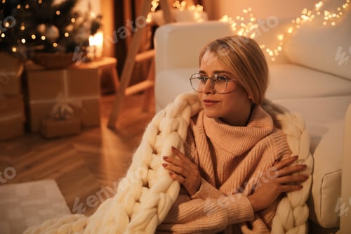 Preview: Young woman with plaid near sofa at home, space for text. Christmas celebration