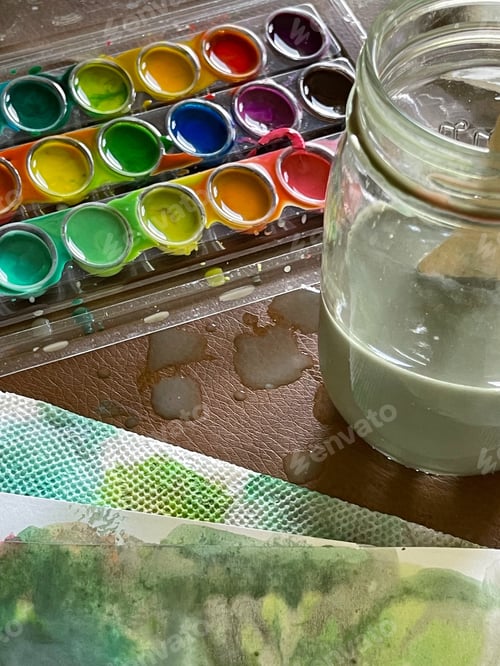 Preview: Watercolor Paint Supplies and Artwork on Tabletop