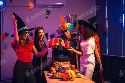 Preview: Asian friends, middle-aged man and young woman, enjoy Halloween office party with vampire costumes