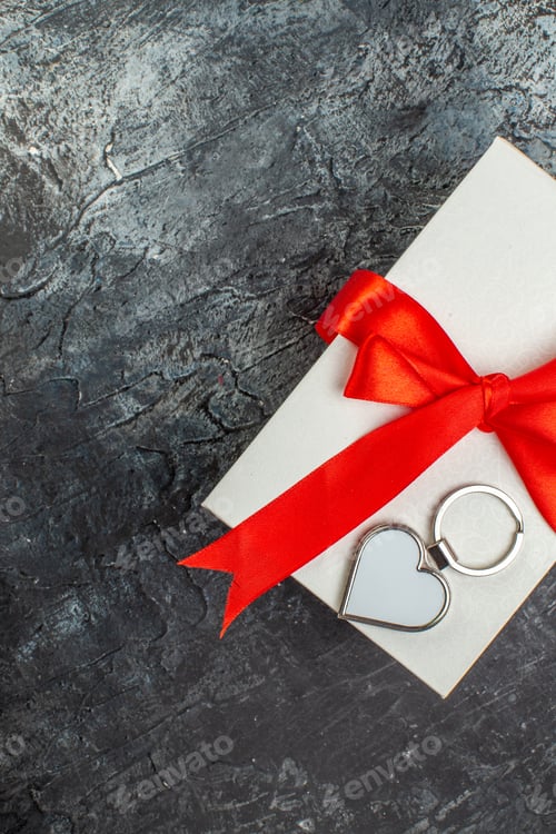 Preview: Half shot of beautifully packaged gift boxes tied with red ribbon on the right side on dark