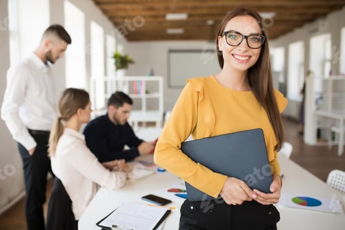Preview: Young smiling business woman in eyeglasses happily looking in ca