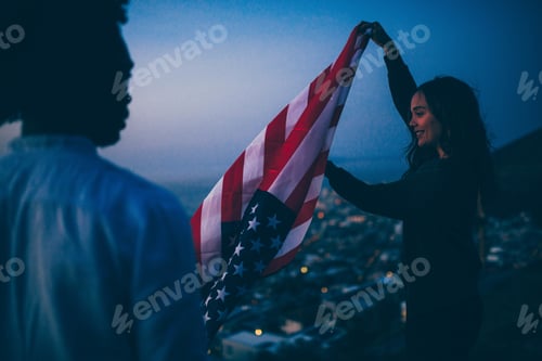 Preview: Friends celebrating with American flag at sunset