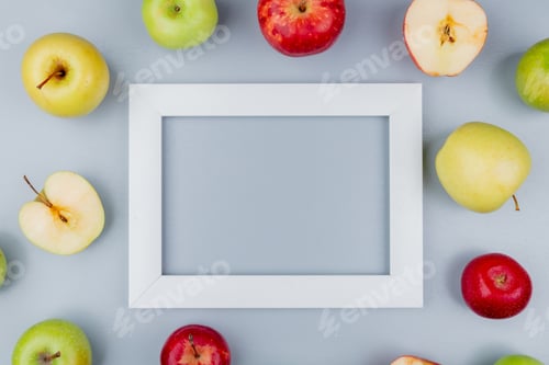 Preview: top view of pattern of cut and whole apples around frame on gray background with copy space