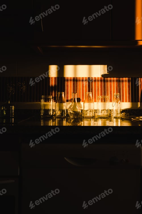 Preview: empty glasses under dramatic light in kitchen