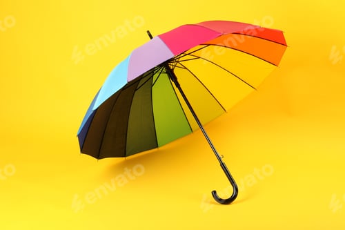Preview: Umbrella of rainbow color on yellow background