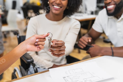 Preview: Real estate agent giving keys to happy couple in coworking space