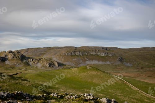 Preview: Scenic view of rolling hills and rocky formations under a cloudy sky in Skipton town, England, UK
