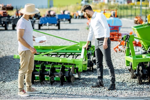 Preview: Agronomist with salesman at the shop with agricultural machinery