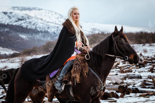 Preview: Woman viking with a black horse against the background of mountains