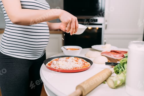 Preview: close up details of pregnant woman making home pizza