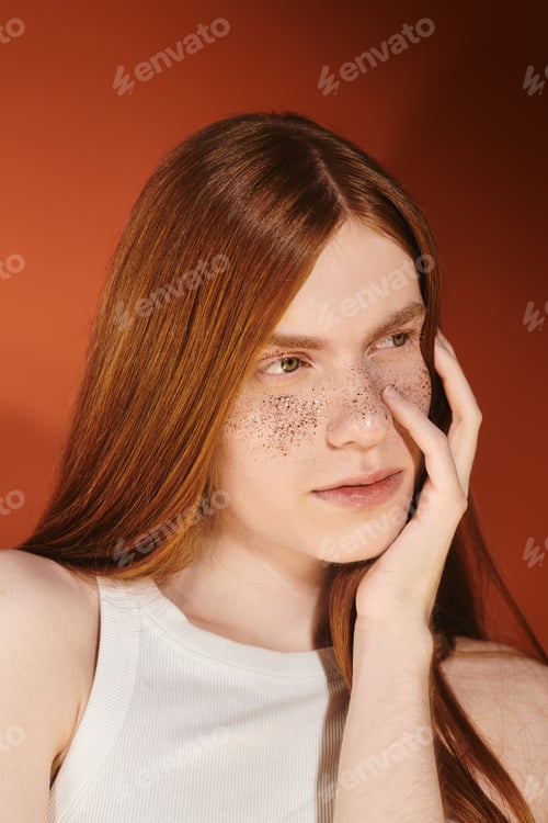 Preview: Stylish young man with long red hair showcasing confidence against a vibrant backdrop