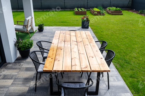 Preview: A modern table made of raw wood covered with yacht varnish, standing on the garden terrace.