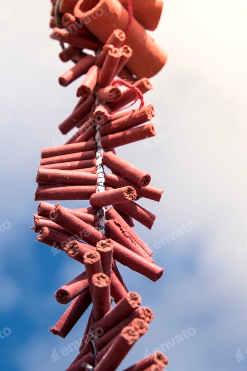 Preview: Close-up of Chinese New Year firecrackers against blue sky and clouds