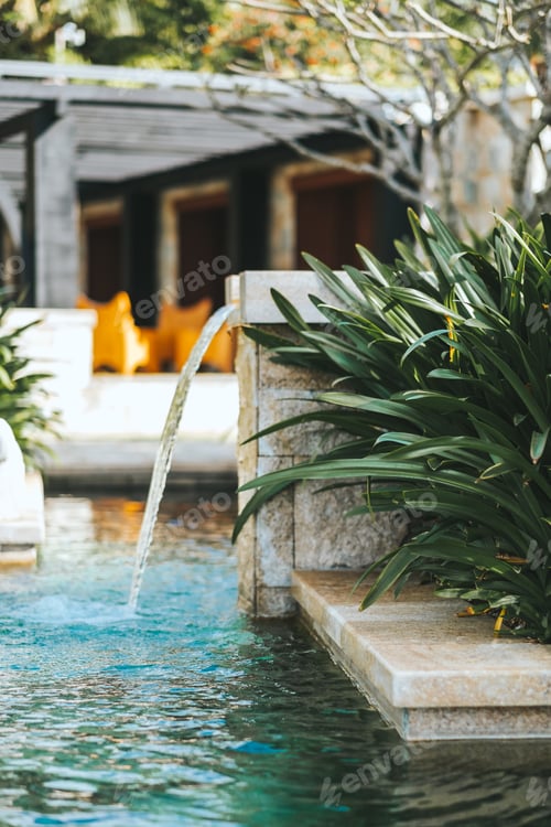Preview: Turquoise water pool exterior in tropics with green vegetation.