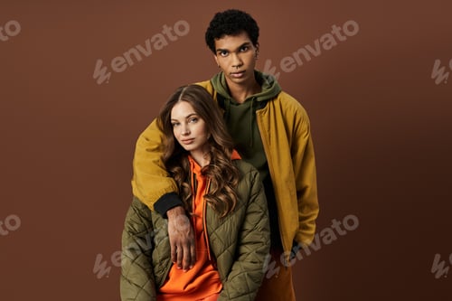 Preview: Stylish young couple embraces autumn vibes in vibrant outfits against a warm backdrop