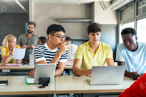 Preview: Group Of Teenage Students Collaborating On Project In IT Class