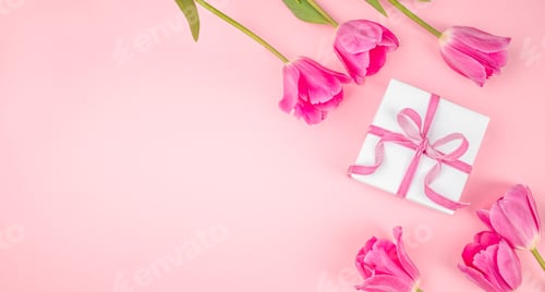 Preview: White gift box with pink ribbon and tulips on pastel pink background with copy space, top view