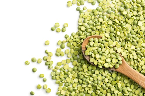Preview: Green split peas in wooden spoon.