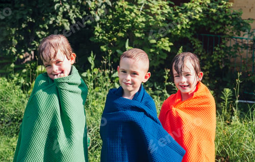 Preview: Happy wet children in towels on a sunny summer day
