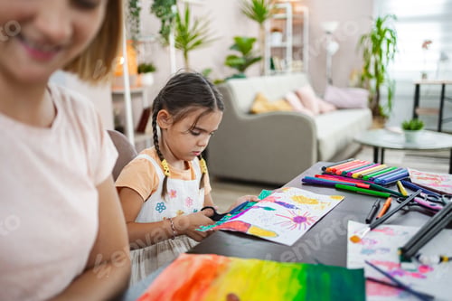 Preview: Mother and daughter engage in creative arts and crafts at home during a sunny afternoon