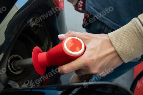 Preview: A man hand holding pump filling gasoline. Pumping petrol into the tank.