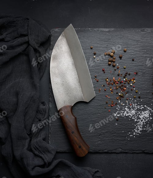 Preview: Large kitchen knife on a black graphite board and spices