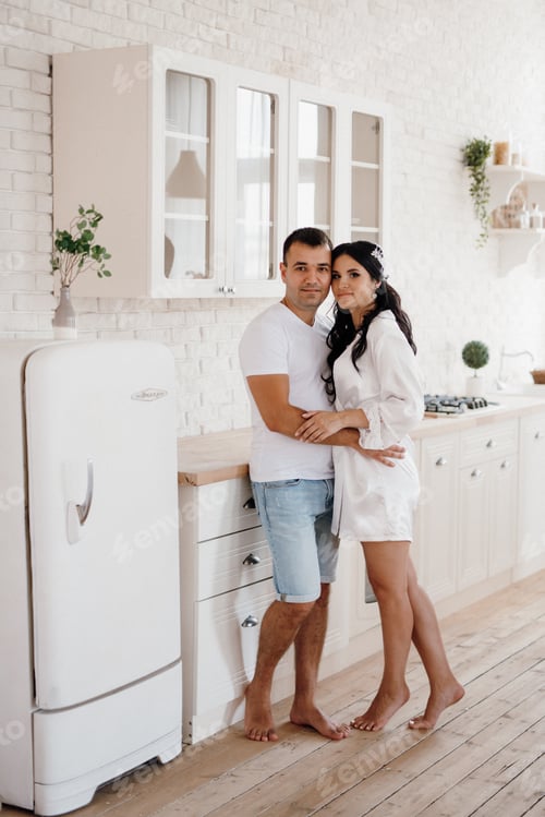 Preview: young couple guy and girl in a large kitchen