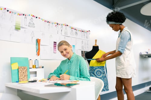 Preview: Side view of diverse female graphic designers working in office