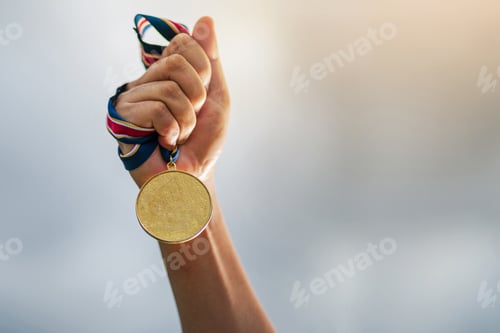 Preview: Hand holding gold medal on sky background