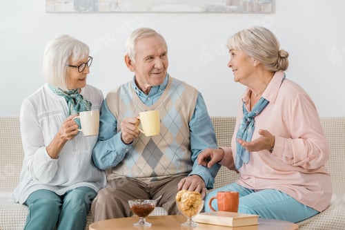 Preview: senior people drinking coffee and talking in nursing home