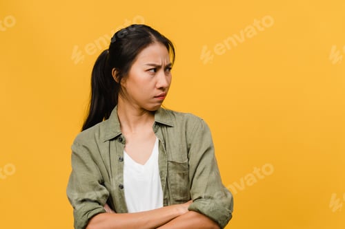Preview: Portrait of young Asia lady with negative expression, excited screaming on yellow background.
