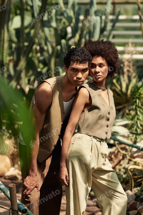 Preview: Young couple sharing a tender moment amidst vibrant greenery in a lush greenhouse