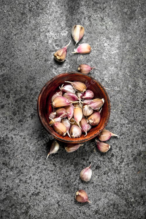 Preview: Peaces of fresh garlic in a wooden bowl.