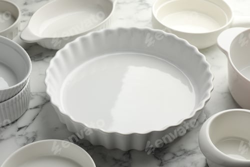 Preview: Different casseroles on white marble table, closeup