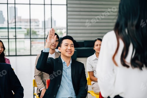 Preview: Within a conference, a young man raises his hand with eagerness to ask a question. The group is a