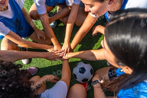 Preview: Women's soccer team joining hands for teamwork huddle