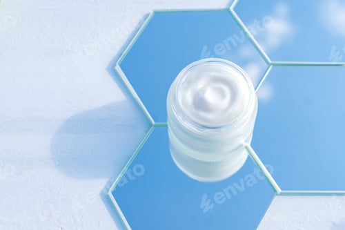 Preview: Moisturizer cream jar in frosted glass bottle on sky background. Close up of skin and body care beau