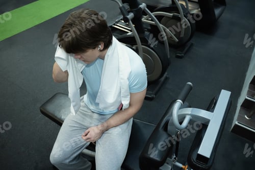 Preview: Resting man gym recovery moment. Workout Routine at Gym