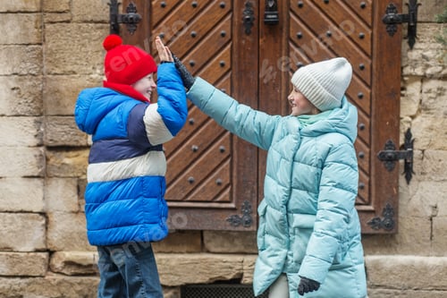 Preview: Happy children giving high five in winter