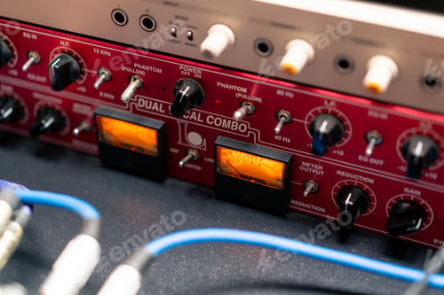 Preview: close-up of buttons and control system of a red microphone preamplifier in a recording music studio
