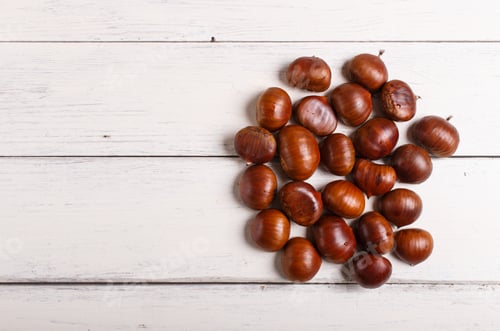 Preview: pile of sweet chestnuts on white wooden background