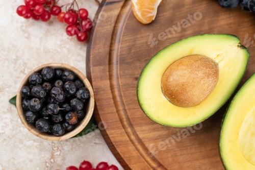 Preview: Sliced avocado with blackcurrant on wooden board