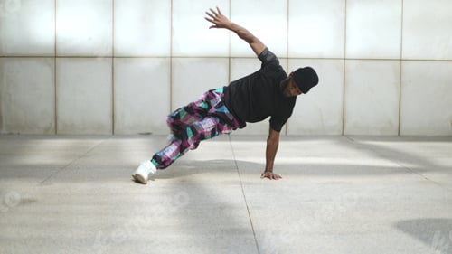 Preview: Breakdancer performing freeze move in urban environment