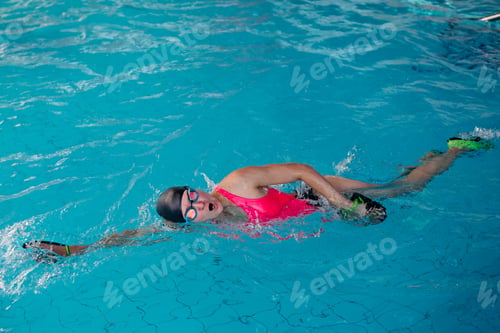 Preview: Female in pink swimwear swimming in blue water pool