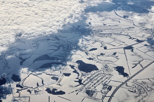 Preview: Aerial view over clouds top to snow covered rivers, fields and roads, winter fresh frosty air