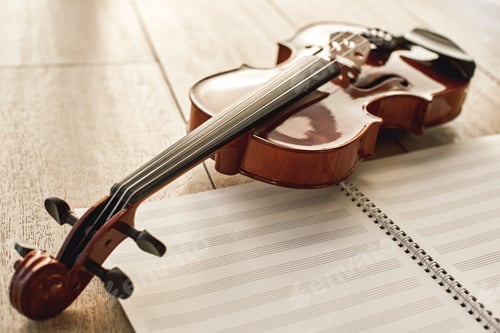 Preview: Visual beauty of classical instrument. Close up view of brown beautiful violin lying on sheets for