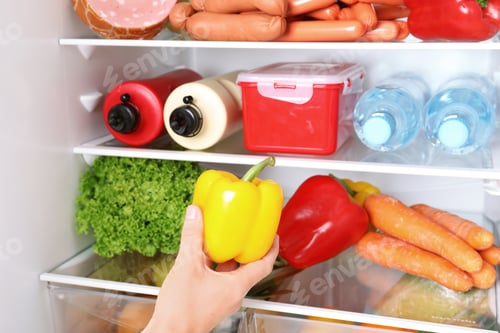 Preview: Woman taking bell pepper from refrigerator, closeup