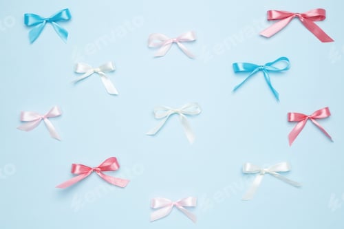 Preview: Multicolored bows on blue background. Top view