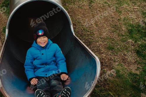 Preview: Children's playground in the yard of a new house, district, The boy is coming down the hill