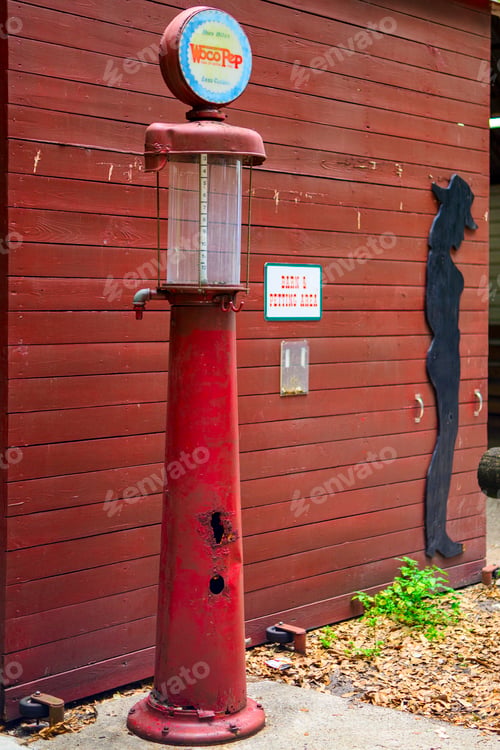 Preview: a red vintage gas pump next to a wall and a fire hydrant